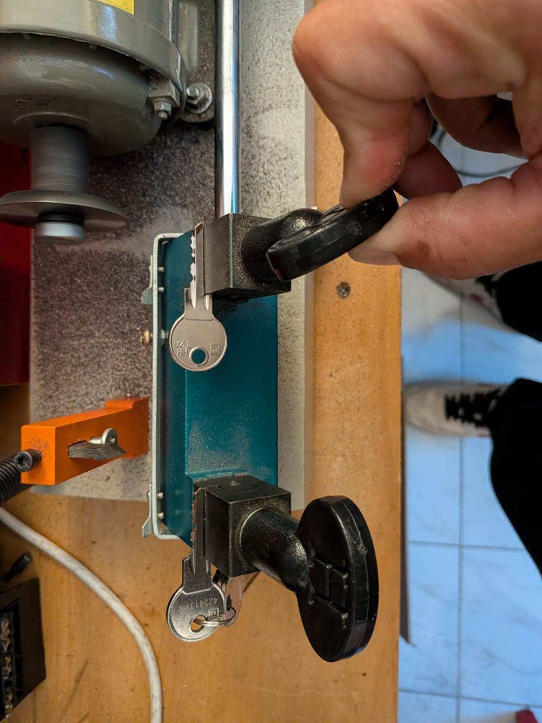 Réglage des serre-joints d’une machine à reproduire les clés sur l’établi.