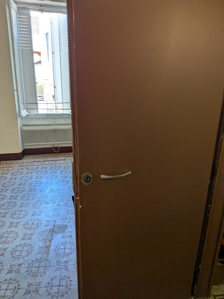 Porte d’appartement à Vacquerolles Nîmes avant remplacement de serrure après squat : ancienne fermeture à sécuriser en urgence.