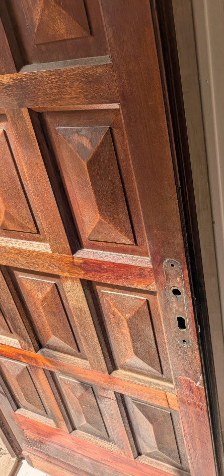 Porte en bois à Castanet Nîmes avant remplacement : ancienne serrure à tringlerie déposée, usinages visibles avant adaptation.
